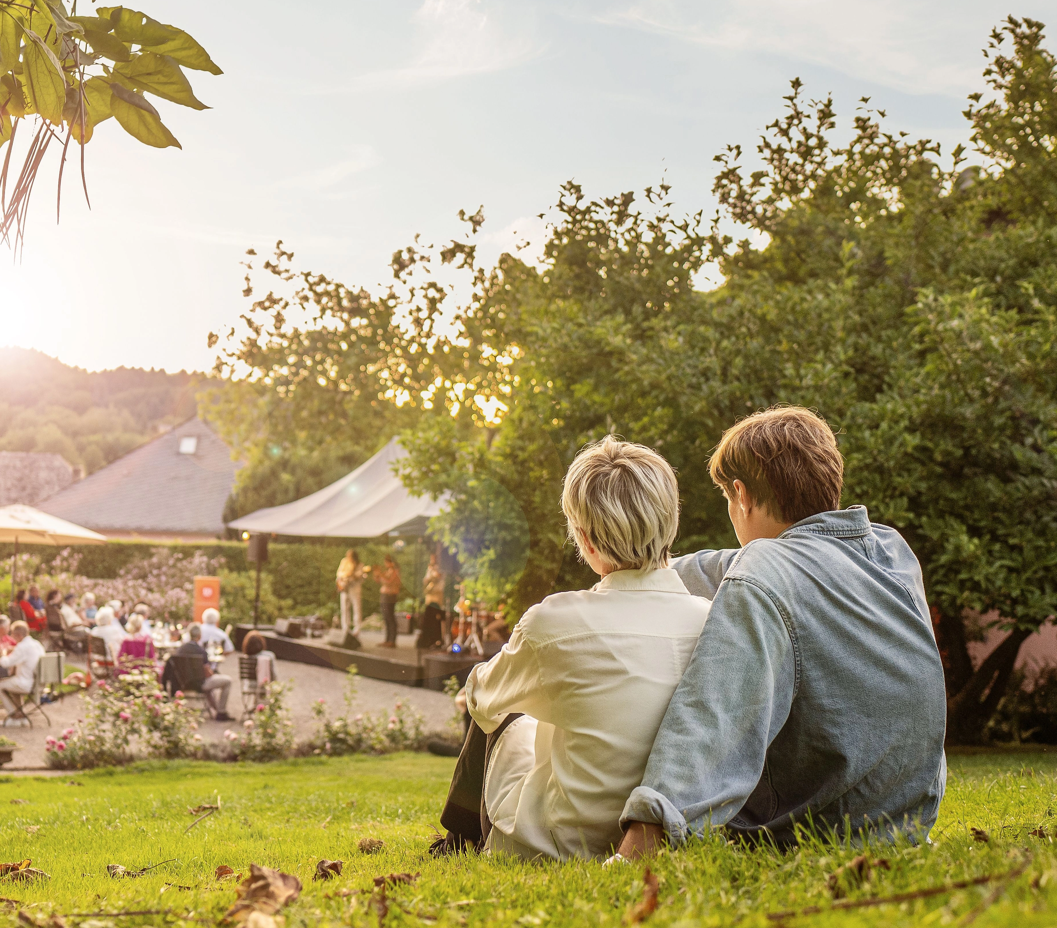 Paar beim Besuch des Mosel Musikfestivals Das Mosel Musikfestival feiert 2025 sein 40-jähriges Bestehen. Im Rahmen der Veranstaltungsreihe treten erstklassige Musiker an außergewöhnlichen Spielstätten entlang der Mosel auf. Von Klassik über Jazz bis hin zur Weltmusik ist alles vertreten.